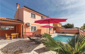 a house with a pool and a red umbrella at Beautiful Home In Betiga With 4 Bedrooms, Wifi And Outdoor Swimming Pool in Barbariga