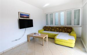 a living room with a yellow couch and a table at 2 Bedroom Amazing Apartment In Klek in Klek
