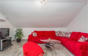 a living room with a red couch and a tv at Nice Apartment In Krk With Wifi in Risika