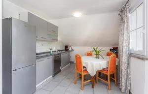 a kitchen with a table with orange chairs and a refrigerator at Nice Apartment In Krk With Wifi in Risika