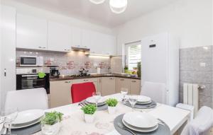 a kitchen with a dining room table with plates and glasses at Beautiful Apartment In Jurdani With Kitchen in Jurdani