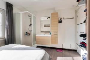 een badkamer met een bed, een wastafel en een spiegel bij Witte berg 01.03 in De Panne