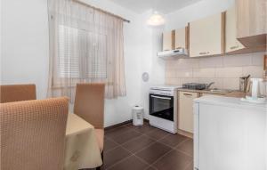 a kitchen with white cabinets and a stove top oven at Awesome Apartment In Novi Vinodolski in Donji Zagon