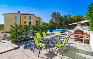 un patio con mesa, sillas y piscina en 3 Bedroom Amazing Apartment In Kostrena, en Žurkovo