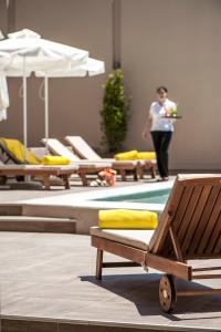 a woman walking in a room with chairs and a table at Kriti Hotel in Chania Town
