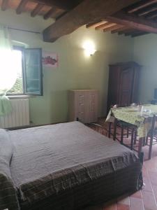 um quarto com uma cama e uma mesa de jantar em Casale Poggio Meone em Santa Luce