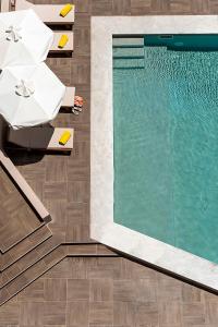 a pool with chairs and umbrellas next to a swimming pool at Kriti Hotel in Chania