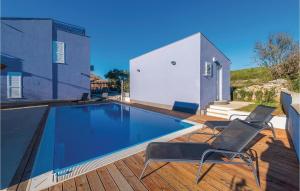 una piscina con 2 sillas y una casa en Lovely Apartment In Veli Rat With Kitchen, en Verunić