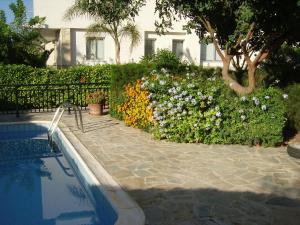 un jardín de flores junto a una piscina en Kissonerga Apartment, en Pafos