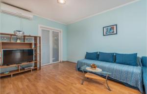 a living room with a blue couch and a tv at Beautiful Apartment In Pinezici With Wifi in Pinezici