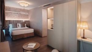 una camera d'albergo con letto e tavolo di Hotel Aquarius Venice-Ascend Hotel Collection a Venezia