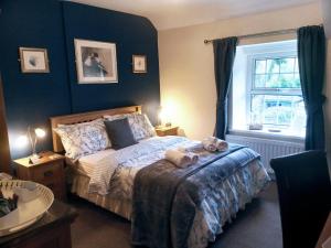 a bedroom with a bed with two teddy bears on it at Oakfield Guest House in Betws-y-coed