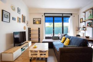 ein Wohnzimmer mit einem blauen Sofa und einem TV in der Unterkunft Apartment 5 minutes from the tram and 10 minutes from the sea in Nizza