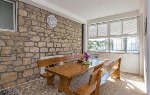 a dining room with a wooden table and a stone wall at Gorgeous Home In Veliki Prolog With Kitchen in Veliki Prolog