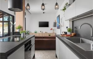 a kitchen with a sink and a living room at Stunning Home In Medulin With Wifi in Medulin