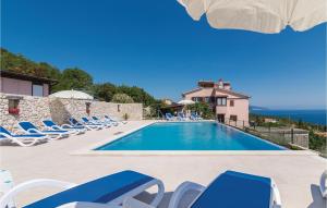 a villa with a swimming pool and chairs at Beautiful Apartment In Labin With House Sea View in Ravni