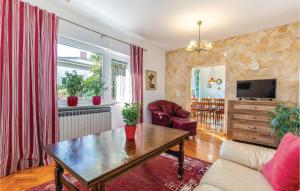 een woonkamer met een bank en een tafel bij 3 Bedroom Cozy Apartment In Kostrena in Kostrena