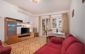 a living room with a red couch and a television at Nice Apartment In Pula With 2 Bedrooms, Jacuzzi And Wifi in Pula