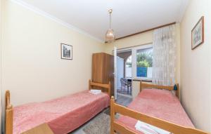 1 dormitorio con 2 camas y ventana en Awesome Apartment In Okrug Gornji With Kitchen, en Trogir