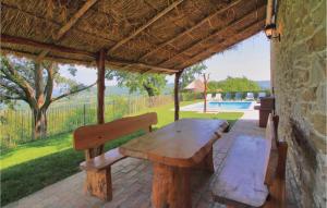 a wooden table and two benches on a patio at Stunning Home In Frki With 3 Bedrooms, Wifi And Outdoor Swimming Pool in Juradi