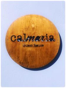 a wooden surfboard with the name calima on it at Calmaria Guesthouse in Porto Covo