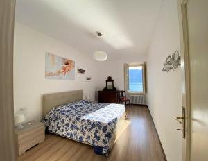 een slaapkamer met een bed, een dressoir en een raam bij Villino De Wels Aparment in Tremezzo in Tremezzo