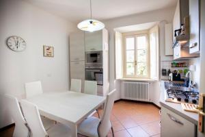 een keuken met een witte tafel en stoelen en een klok bij Villino De Wels Aparment in Tremezzo in Tremezzo