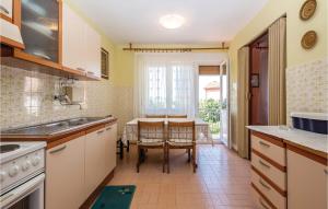 a kitchen with a table and a dining room at Beautiful Apartment In Crikvenica With 2 Bedrooms And Wifi in Crikvenica