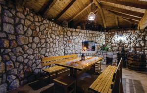 a dining room with benches and a stone wall at Lovely Home In Zaton With Private Swimming Pool, Can Be Inside Or Outside in Zaton