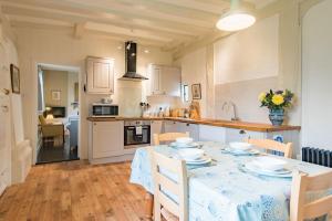 a kitchen with a table with chairs and a tablecloth on it at Bonnington Cottage by Bloom Stays in Canterbury