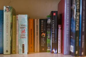 a row of books sitting on a shelf at Bonnington Cottage by Bloom Stays in Canterbury