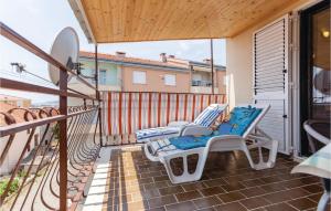 a patio with two chairs and a surfboard on a balcony at 3 Bedroom Stunning Apartment In Trogir in Trogir