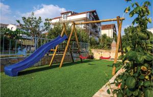 a playground with a blue slide in a yard at 3 Bedroom Stunning Apartment In Trogir in Trogir