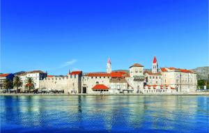 a large building on the shore of a body of water at Amazing Apartment In Trogir With 3 Bedrooms And Wifi in Trogir