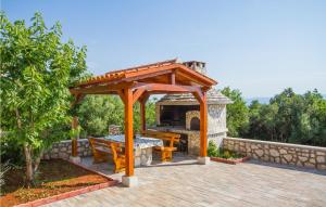 a wooden gazebo with a picnic table and a grill at Stunning Apartment In Labin With Kitchen in Ravni