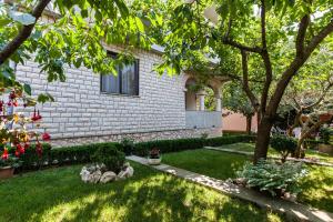 dom z ogródkiem z trawą i kwiatami w obiekcie Guest House Perica w mieście Zadar