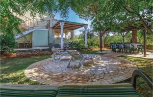a patio with chairs and tables in a yard at Cozy Apartment In Tar With House Sea View in Tar