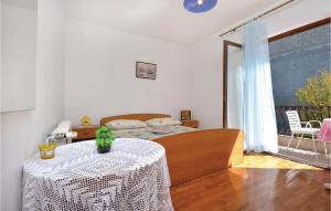 a bedroom with a bed and a table with a white table cloth at Beautiful Apartment In Vrboska With Kitchenette in Vrboska