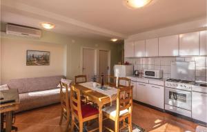 Gorgeous Apartment In Ploce With Wifi في بلوتشي: مطبخ وغرفة معيشة مع طاولة وأريكة