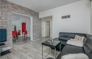 salon z czarną kanapą i telewizorem w obiekcie Cozy Apartment In Vrbnik w mieście Vrbnik