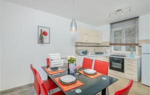 kuchnia z czarnym stołem i czerwonymi krzesłami w obiekcie Cozy Apartment In Vrbnik w mieście Vrbnik