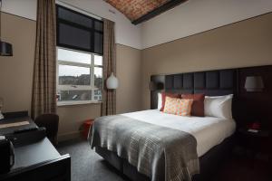 a bedroom with a large bed and a window at Hotel Indigo - Dundee, an IHG Hotel in Dundee