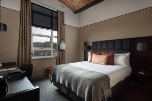 a bedroom with a large bed and a window at Hotel Indigo - Dundee by IHG in Dundee