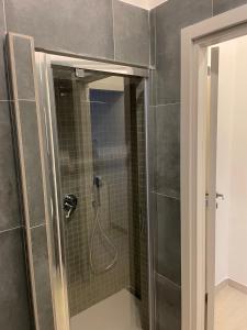 W łazience znajduje się prysznic ze szklanymi drzwiami. w obiekcie Blue & Grey downtown Foggia w mieście Foggia