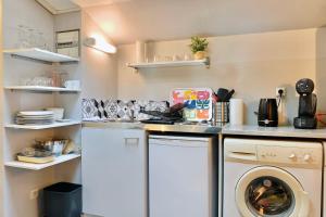 een kleine keuken met een wasmachine en droger. bij Le Colorful T2 City center near tram A #C5 in Grenoble
