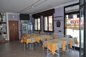 a restaurant with tables and chairs with yellow napkins on them at Hotel Mantova Sud in Bagnolo San Vito