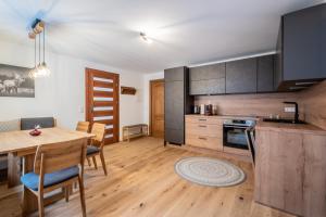 eine Küche und ein Esszimmer mit einem Holztisch und Stühlen in der Unterkunft Bergzeit Appartments in Bad Gastein