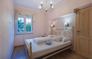 a bedroom with a bed with a chandelier and a window at Beautiful Apartment In Pula With 3 Bedrooms And Wifi in Pula