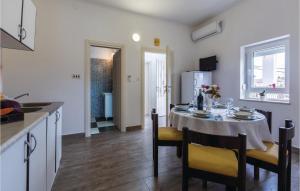 uma cozinha e sala de jantar com mesa e cadeiras em 2 Bedroom Cozy Apartment In Porec em Jasenovica