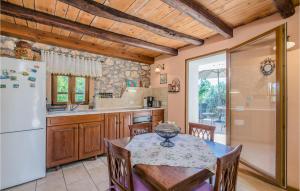 kuchnia ze stołem i lodówką w obiekcie Nice Home In Gostinjac With Wifi w mieście Gostinjac +37 zdjęć